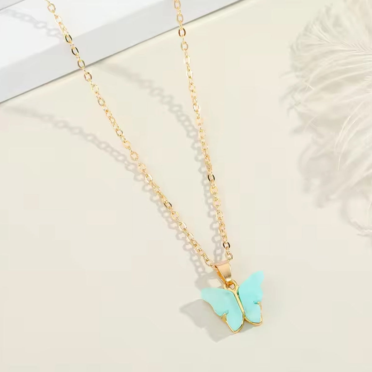 Assorted charm chain necklace with pink hearts and butterflies.