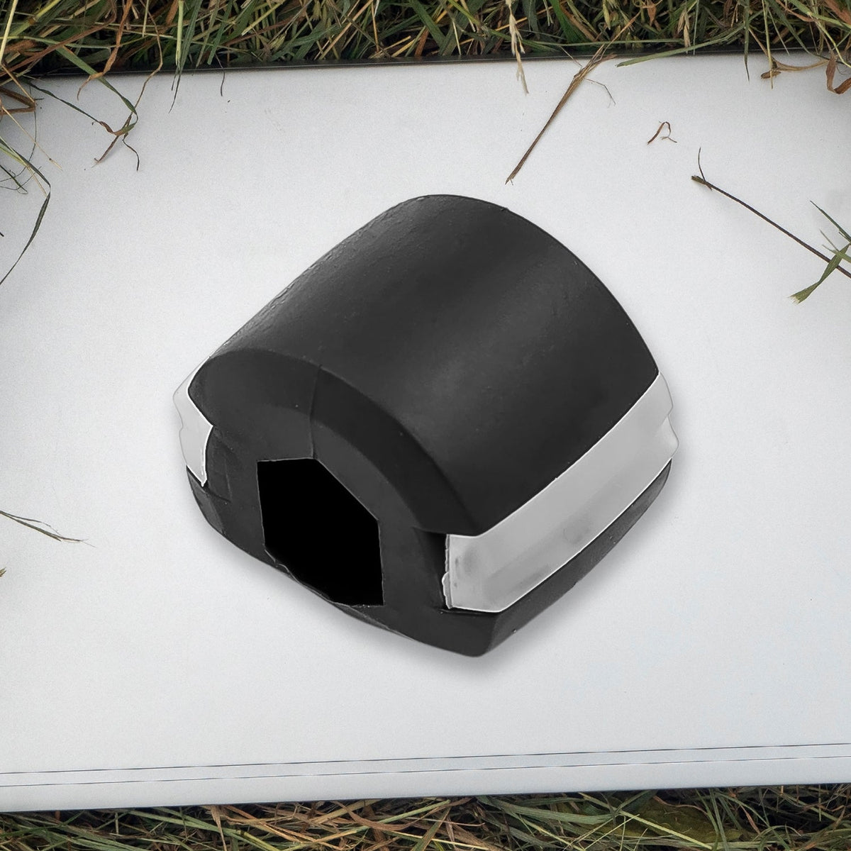 Side profile of the black Jaw Exerciser, showing its compact size.