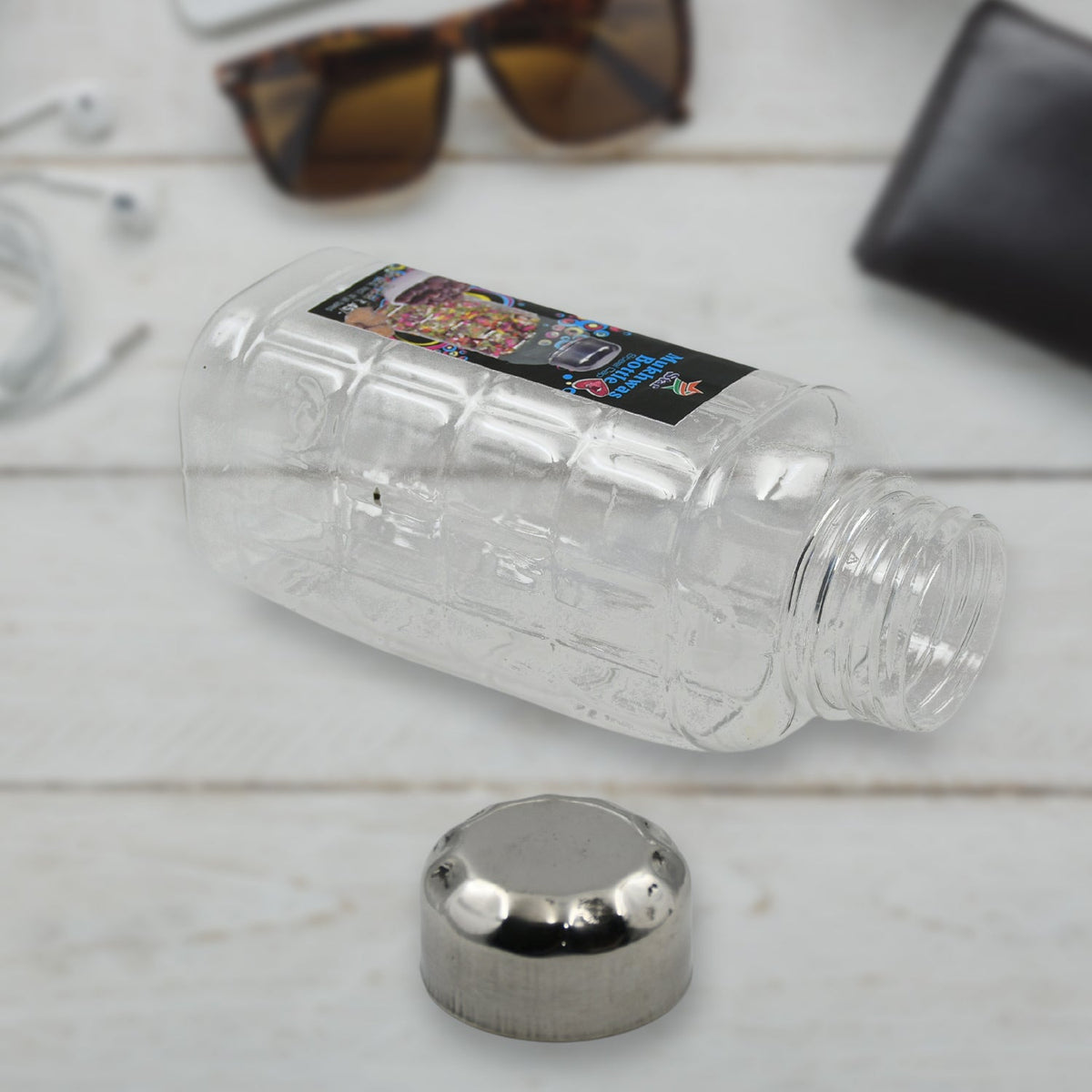 Transparent plastic mukhwas bottle with steel cap on white background