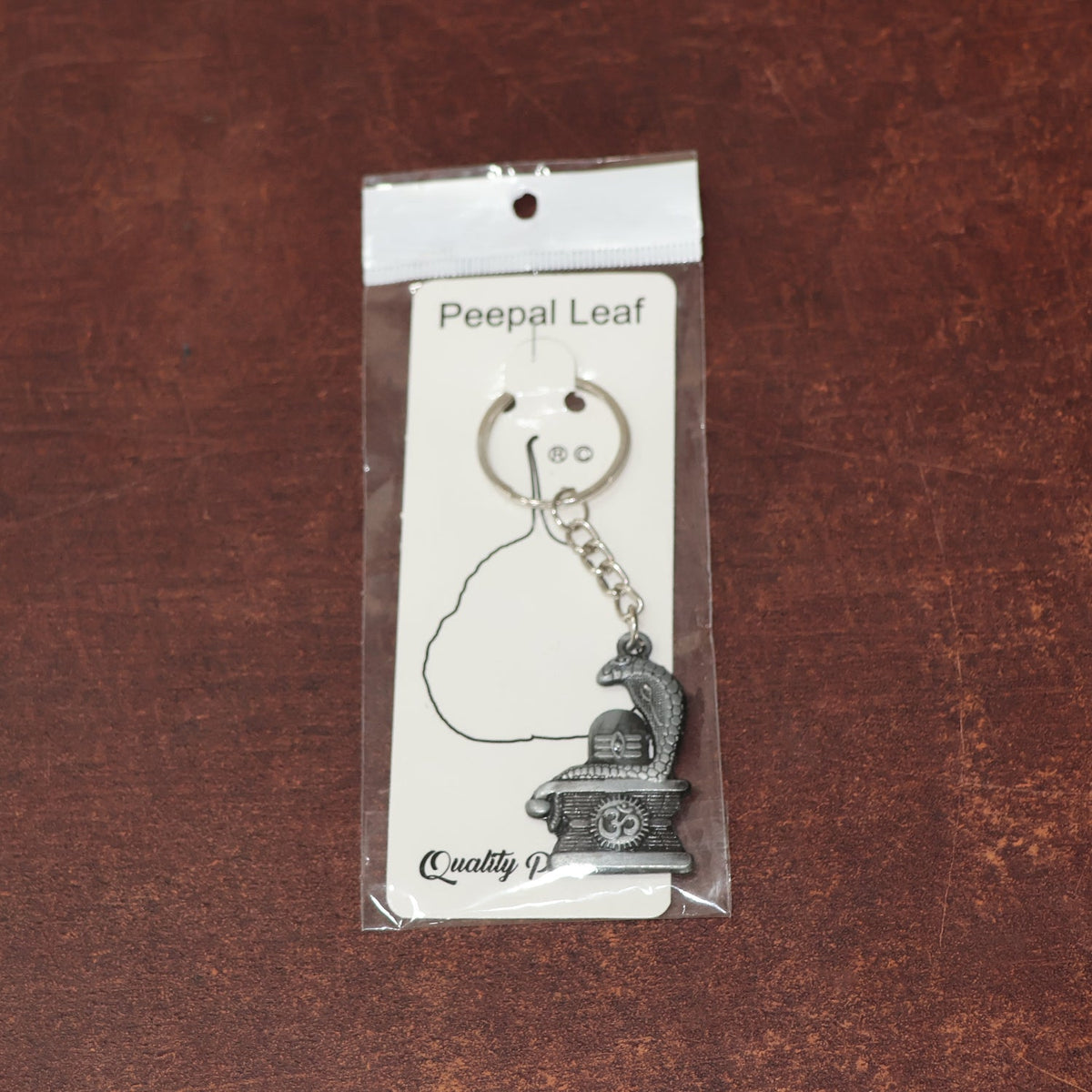 Display of durable metal Shivling keychain with snake design
