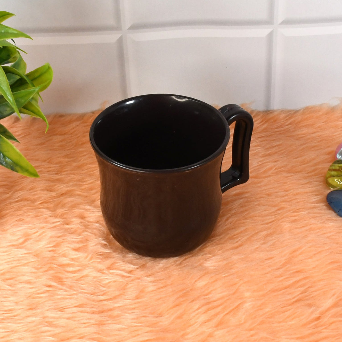 Stylish black plastic tea cup displayed alongside coffee beans, highlighting its versatility.