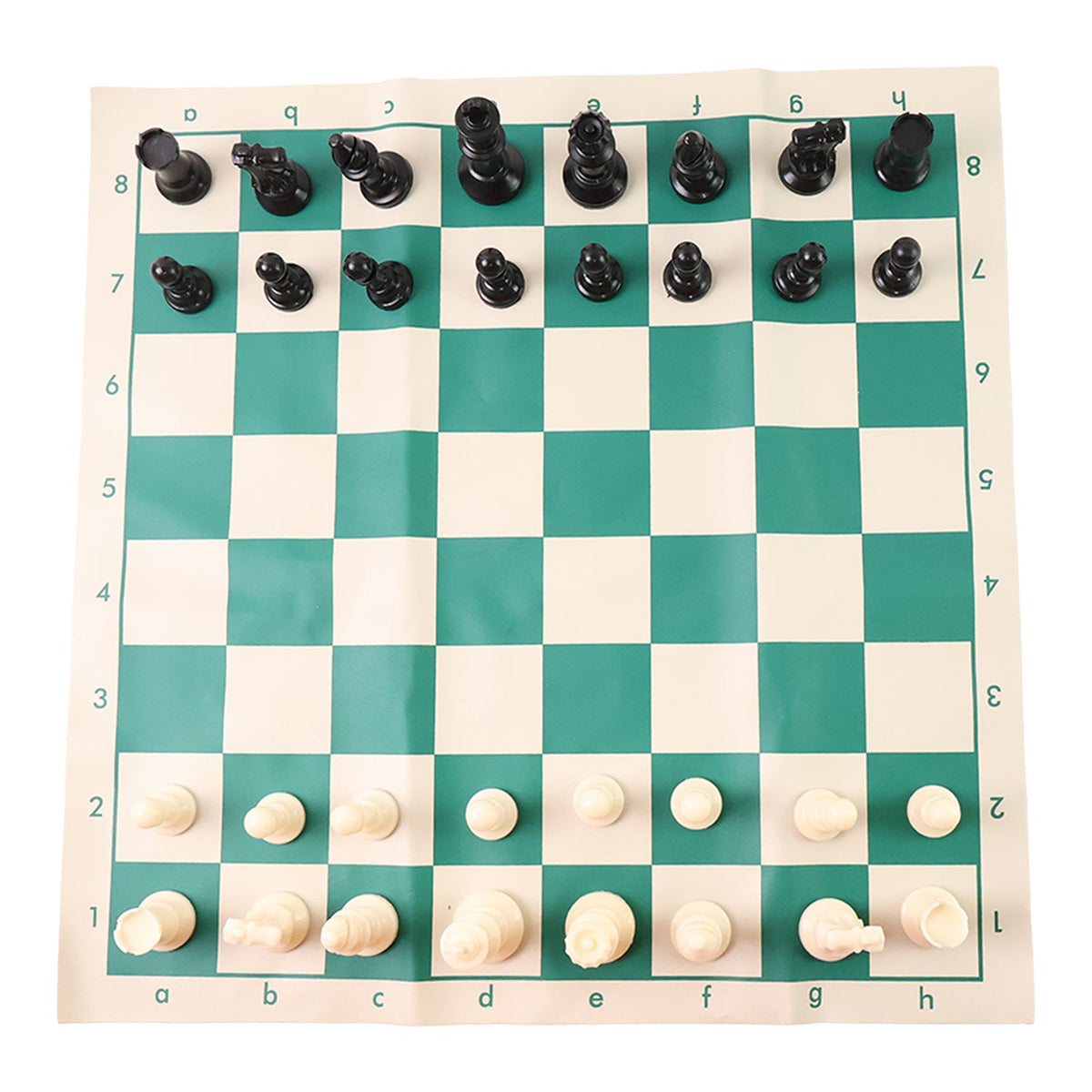 Plastic chess set pieces arranged on the roll-up green and white chess board