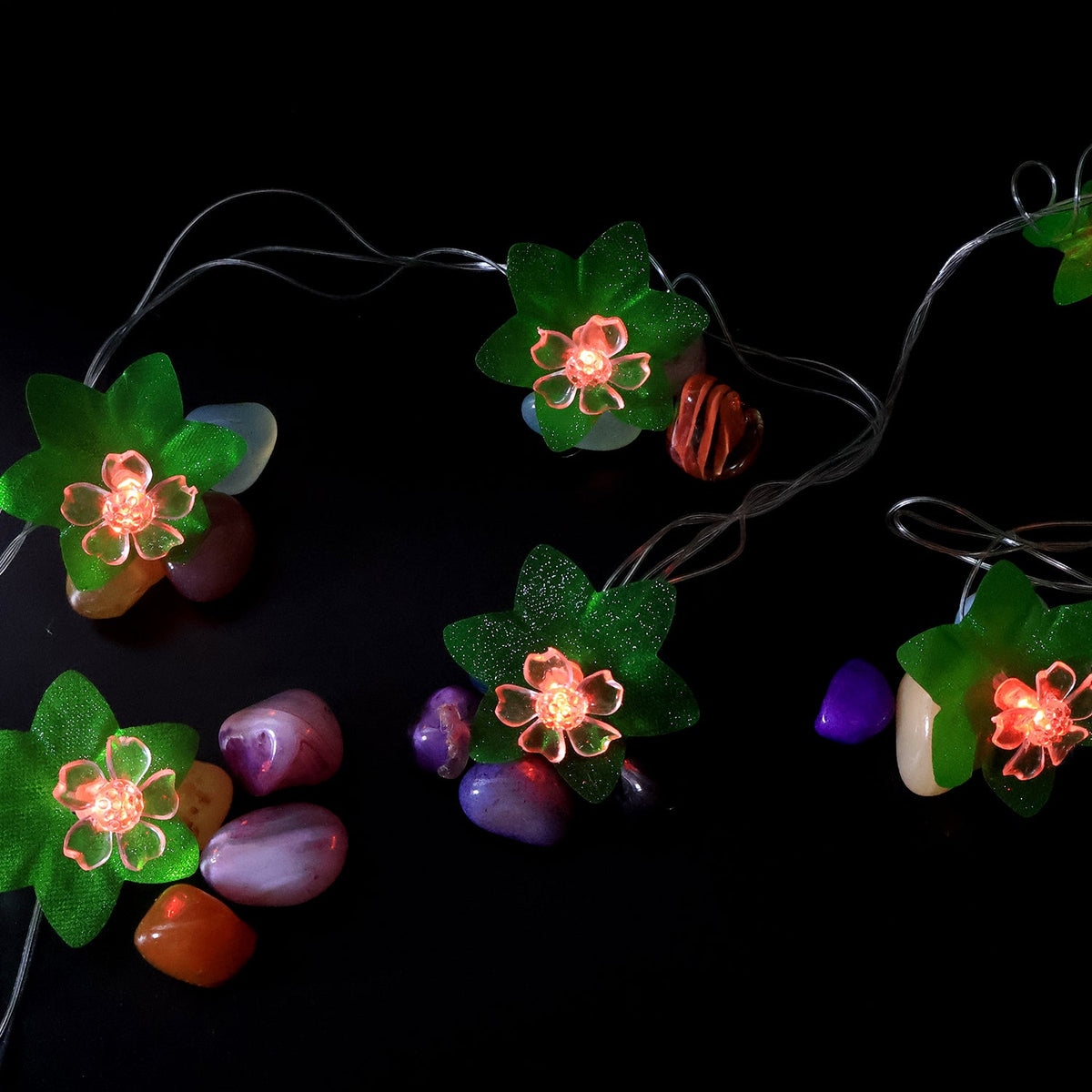 Close view of multi-color LED decorative string light showcasing leaf and flower motifs
