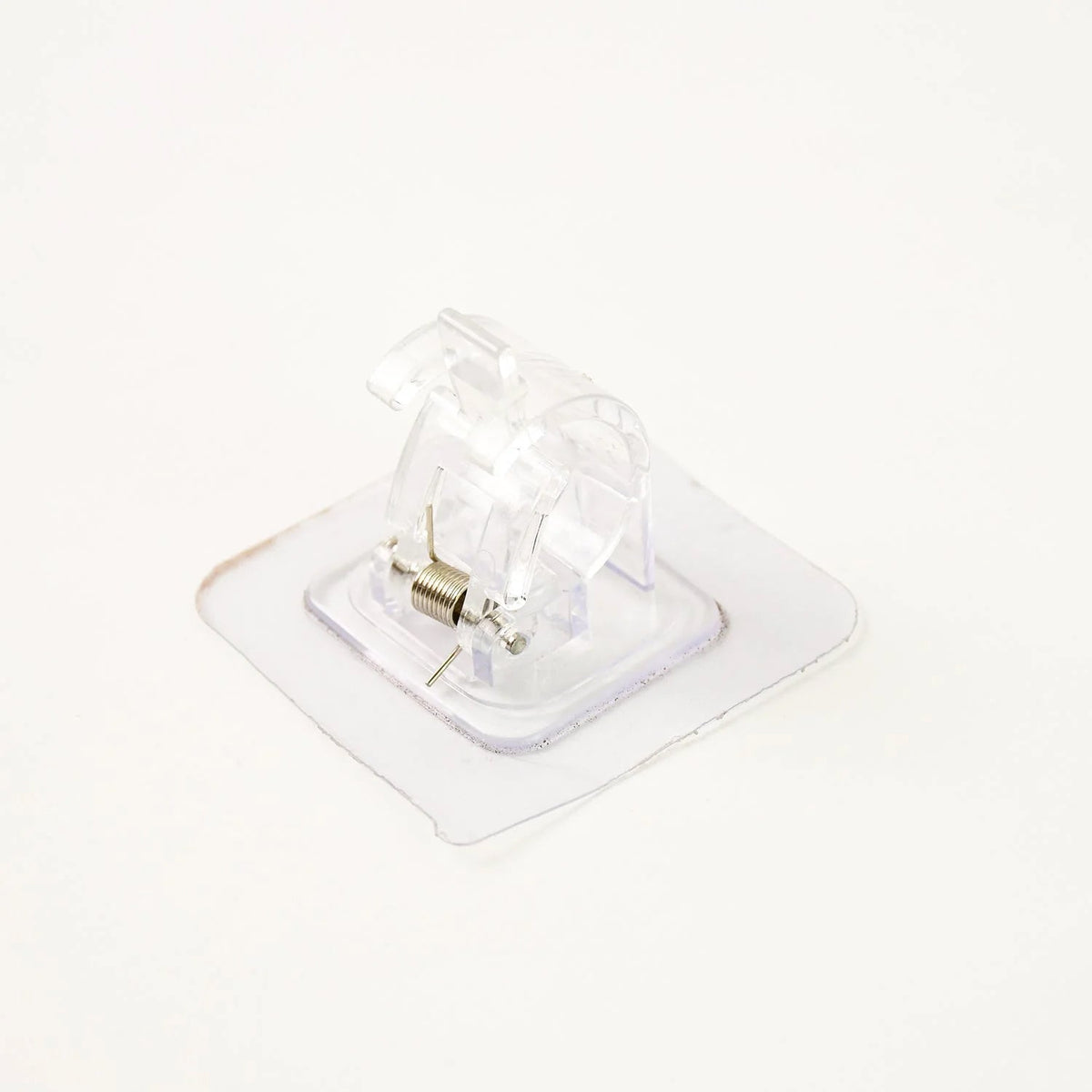 Self-adhesive curtain rail clip installed on wall for lightweight curtains