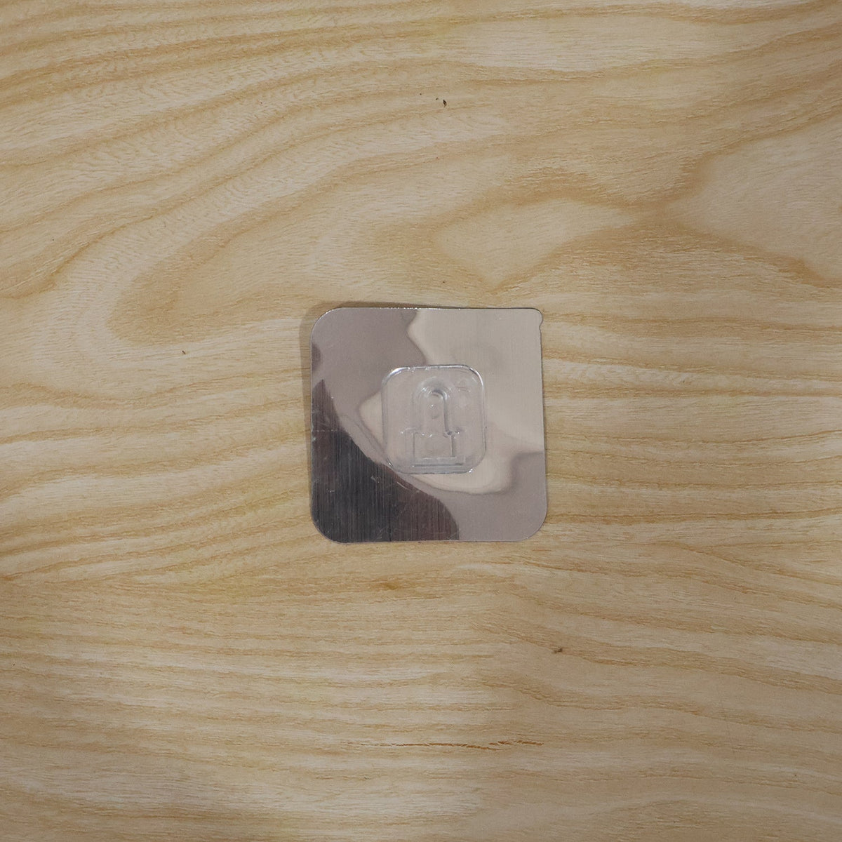 Self adhesive wall hook securely holding items in a home setting.