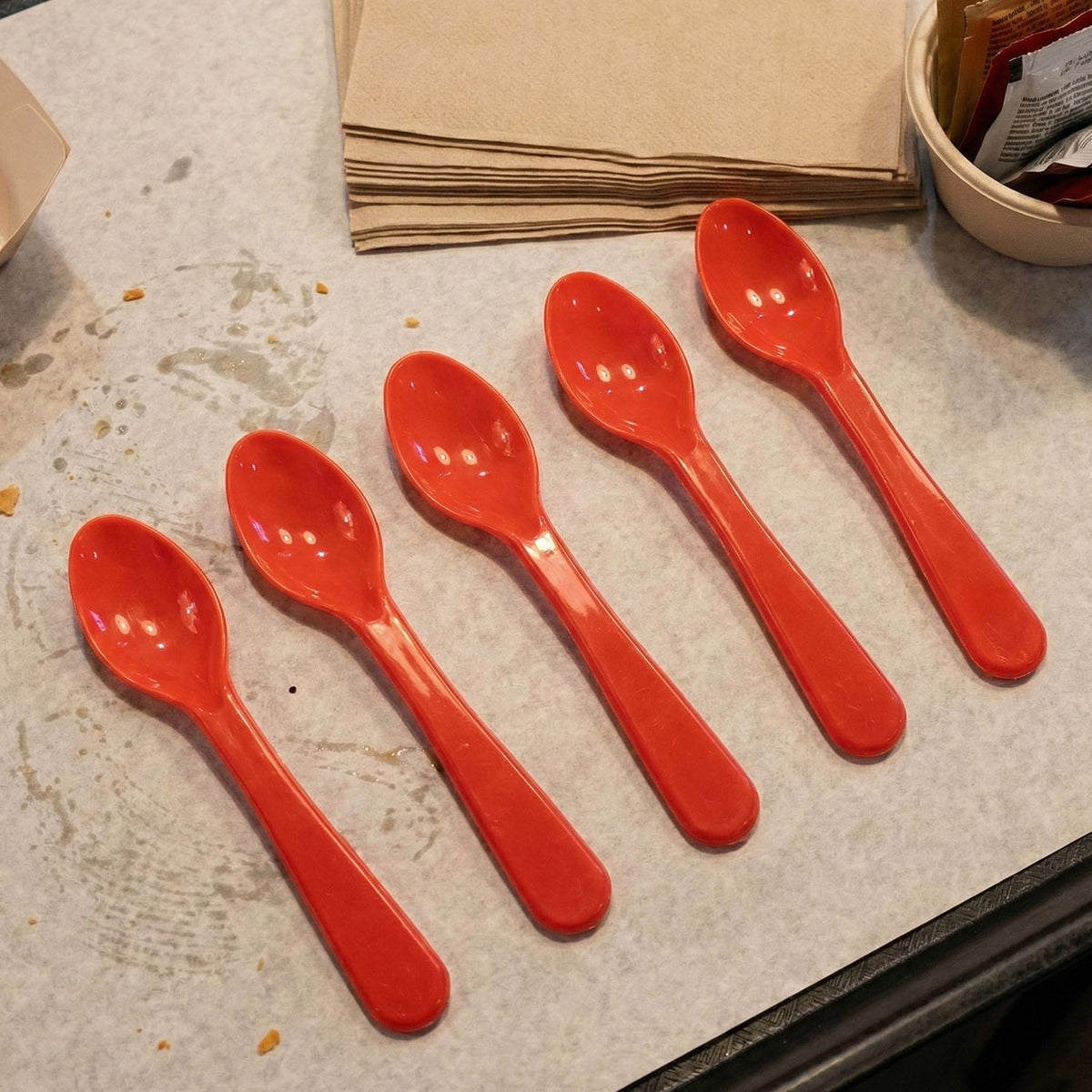 A person comfortably eating a meal from a plate using a white plastic spoon.