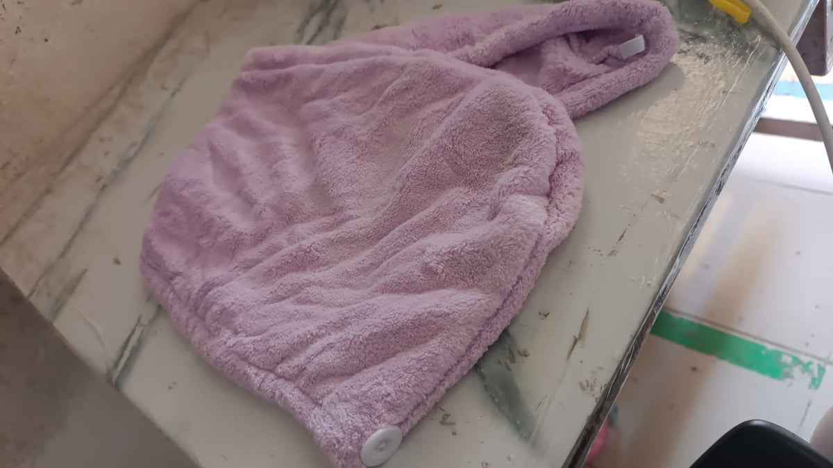 Lifestyle image of a woman comfortably wearing the VelvaBloom turban towel.